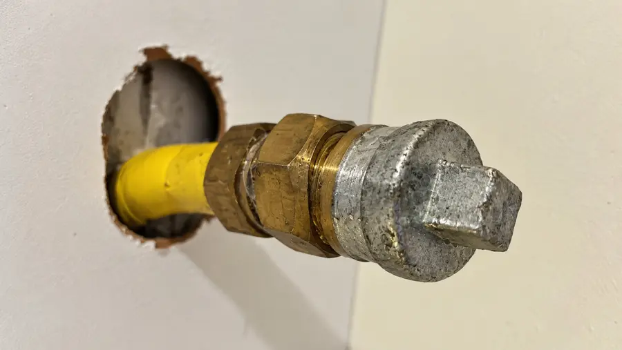 Afgedopte gasleiding met messing koppeling en stop uit de wand